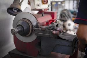 Mechaniker, der die Bremse repariert, verwendet Drehbankwerkzeug, das Scheibenbremsen poliert foto