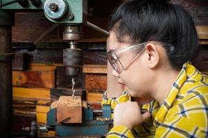 Frauen stehen ist Handwerksbohrer Holz foto