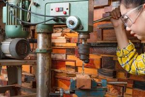 Frauen stehen ist Handwerksbohrer Holz foto