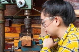 Frauen stehen ist Handwerksbohrer Holz foto