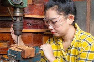 Frauen stehen ist Handwerksbohrer Holz foto