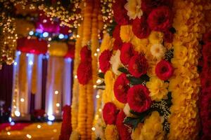 ein Hochzeit Zeremonie mit rot und Gelb Blumen. KI-generiert foto