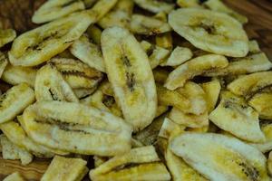 getrocknete Bananenchips auf Olivenholz foto