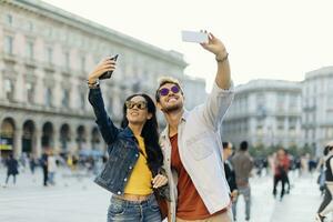 glücklich jung Paar nehmen Selfies im das Stadt, Mailand, Italien foto