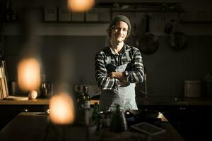 stolz Hobby Koch Stehen im seine Küche, mit Waffen gekreuzt foto