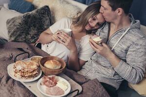 jung Paar haben Frühstück im Bett foto