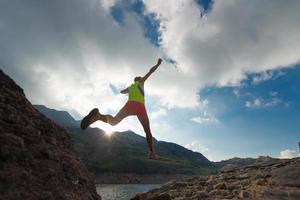 Mädchen überspringen, während er in den Bergen läuft foto