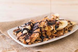 Mandel-Bananen-Pfannkuchen mit Schokoladensirup foto