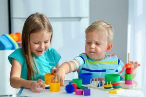 Schwester hilft wenig Bruder zu montieren das Pyramide. lehrreich logisch Spielzeuge zum Kinder. montessori Spiele zum Kind Entwicklung. foto