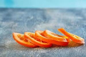 Scheiben von getrockneten Orangen oder Mandarinen auf blauem Hintergrund foto