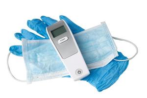 Digitalthermometer auf Maske und blauem Globus zum Schutz des Coronavirus foto