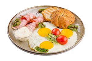 Teller von Frühstück mit gebraten Eier, Speck und Toast isoliert auf Weiß foto