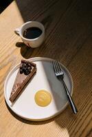 Schokolade Kuchen mit ein Kaffee Tasse auf hölzern Tabelle foto