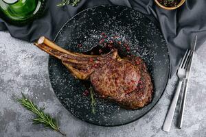 gegrillt Schweinefleisch Steak mit Knochen im Soße auf schwarz Teller foto
