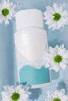 Shampoo oder Haut Pflege Produkte und Kamille Blumen auf ein Weiß Oberfläche mit klar Wasser foto