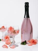 Rosen im Rosa Champagner Brille mit Champagner Flasche foto