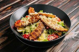 Caesar Salat mit Lachs auf hölzern Tabelle foto