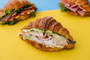 Croissant Sandwich Schinken auf Gelb mit Blau Hintergrund foto