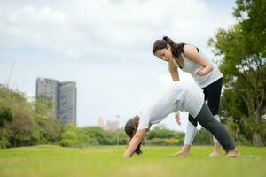 jung weiblich und wenig Mädchen mit draussen Aktivitäten im das Stadt Park, Yoga ist ihr gewählt Aktivität. foto