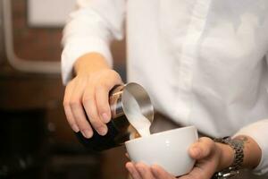 Barista Gießen Kaffee in ein Tasse im Kaffee Geschäft, Nahansicht foto