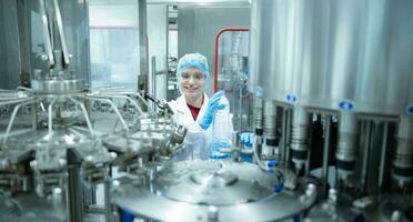 weiblich Qualität Steuerung Arbeiter inspizieren Wasser Flasche auf Produktion Linie im Trinken Wasser Fabrik foto