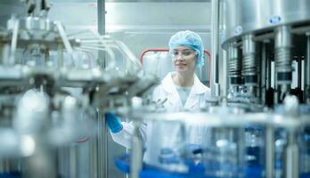 weiblich Qualität Steuerung Arbeiter inspizieren Wasser Flasche auf Produktion Linie im Trinken Wasser Fabrik foto