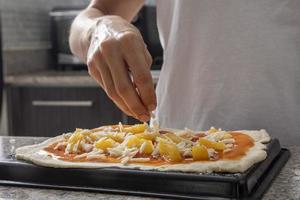 Frauenhände, die Pizza Nahaufnahme vorbereiten foto