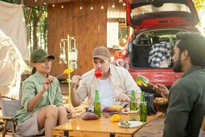 Gruppentouristen trinken Bieralkohol und spielen Gitarre zusammen mit Spaß und Glück im Sommer beim Camping foto