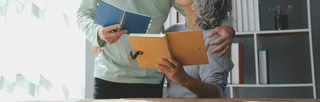 Senior asiatisch Paar Sitzung auf Couch lesen ein Buch zusammen foto