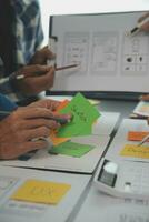 Nahaufnahme von UX-Entwicklern und UI-Designern beim Brainstorming über das Wireframe-Design der mobilen App-Schnittstelle auf dem Tisch mit Kundeninformationen und Farbcode in der Agentur für moderne digitale Entwicklung von Office.Creative foto