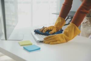 Büro Reinigung Service. Hausmeister Sprühen Schreibtisch. Arbeitsplatz Hygiene foto