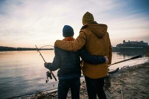 Vater und Sohn sind bereit zum Angeln auf Winter Tag. Fluss Angeln. foto