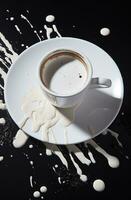 Kaffee Tasse auf ein schwarz Hintergrund mit spritzt von Milch. ai generativ foto
