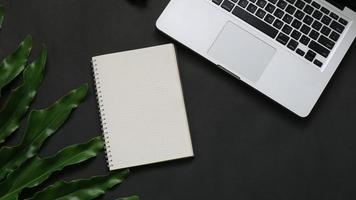 Notebook-Blatt-Laptop mit Draufsicht auf schwarzem Hintergrund