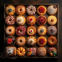Sortiment von Donuts im hölzern Box auf dunkel Hintergrund, foto