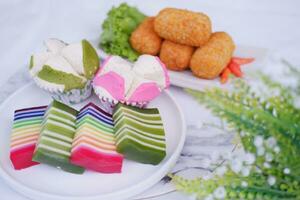 gebraten Kroketten, Schwamm Cupcake und Regenbogen klebrig Schicht Kuchen indonesisch traditionell Dessert foto