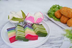 gebraten Kroketten, Schwamm Cupcake und Regenbogen klebrig Schicht Kuchen indonesisch traditionell Dessert foto