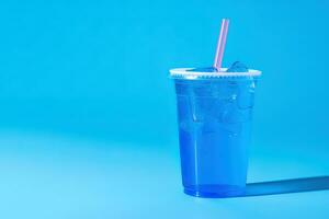 Blau trinken im ein Plastik Tasse isoliert auf ein Blau Hintergrund. nehmen Weg Getränke Konzept mit Kopieren Raum. ai generiert foto