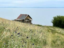 einsam Hütte auf das Ufer von See Baikal, Russland foto