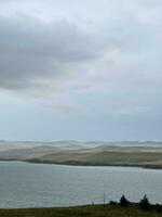 See Baikal im das früh Morgen, nebelig Dunst Über das Wasser. düster hart Landschaft foto