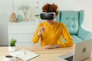 afrikanisch amerikanisch jung Frau tragen mit virtuell Wirklichkeit Metaverse vr Brille Headset beim heim. Mädchen berühren Luft während vr Erfahrung auf virtuell Wirklichkeit Helm. Simulation Hi-Tech Videospiel Konzept. foto