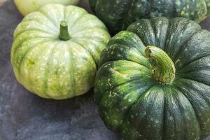 herbstlicher Hintergrund. natürlicher herbst herbstansicht kürbisse auf dunkelschwarzem steinschieferhintergrund, oktober oder september tapete wechsel der jahreszeiten reifes bio-lebensmittelkonzept halloween-party erntedankfest foto