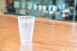Glas Wasser auf dem Tisch foto