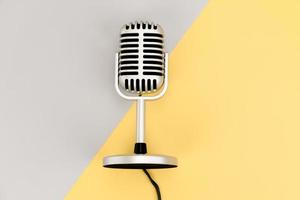 Retro-Mikrofon der Draufsicht mit Kopienraum auf Grau und Gelb foto
