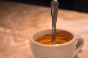 Tasse heißen Kaffee mit Löffel drin foto