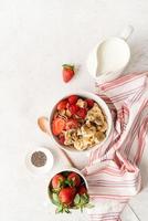 gesundes Frühstück, Müsli, frische Beeren und Milch in einer Schüssel, Ansicht von oben foto