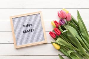 Tulpenblumen und Briefbrett mit den Worten Frohe Ostern