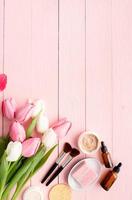 Blick von oben auf die Kosmetik mit rosa und weißen Tulpen foto