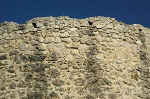 ein Stein Mauer mit ein groß Vogel auf es foto