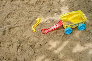 eben legen von ein Strand Spielzeug Kit Verbreitung aus auf das sandig Oberfläche von ein draussen Spielplatz. foto